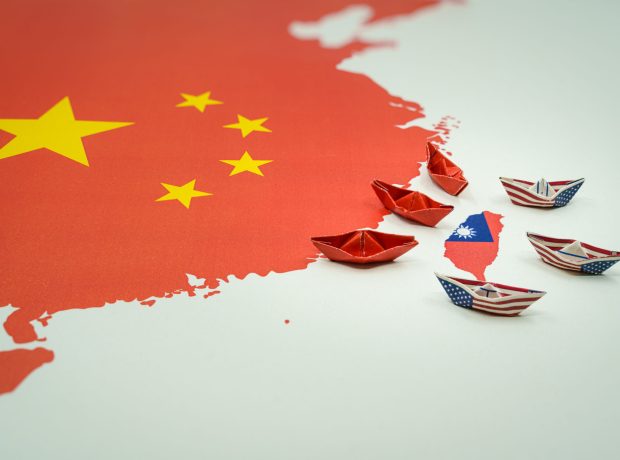 image-paper-boats-with-the-colors-of-the-usa-and-china-surrounding-the-island-of-taiwan-on-a-map