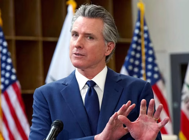 image-gavin-newsom-speaking-during-a-press-conference-in-front-of-american-and-california-state-flags-in-turlock-ca-2025